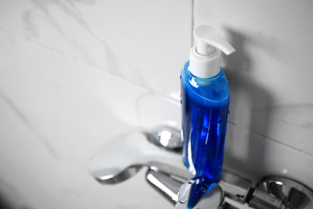 Bottle of shower gel on faucet in bathroom. Space for textの写真素材