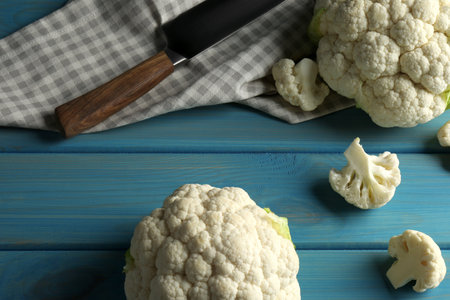 Fresh whole and cut cauliflowers on light blue wooden tableの写真素材