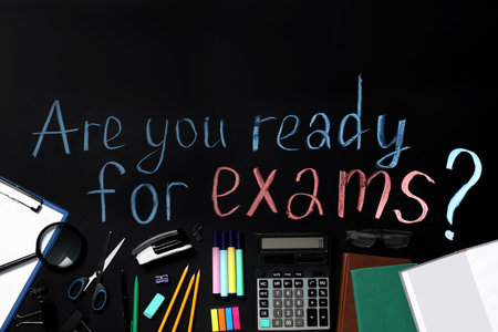 Black chalkboard with phrase Are You Ready For Exams and different stationery, flat layの写真素材