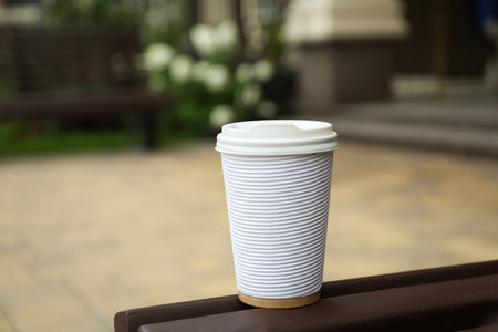 Paper cup of coffee on wooden bench outdoors. takeaway drinksの写真素材