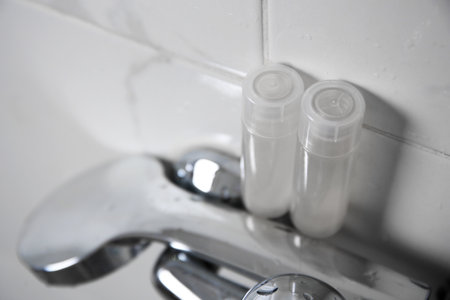 Bottles of shower gel on faucet in bathroom. Space for textの写真素材