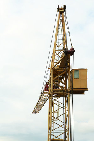 Construction site with tower crane under cloudy sky