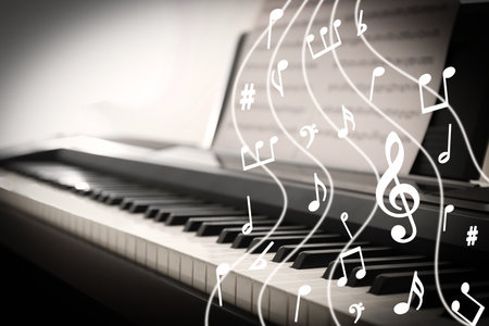Music notes and other musical symbols over piano, closeup. black and white effectの写真素材