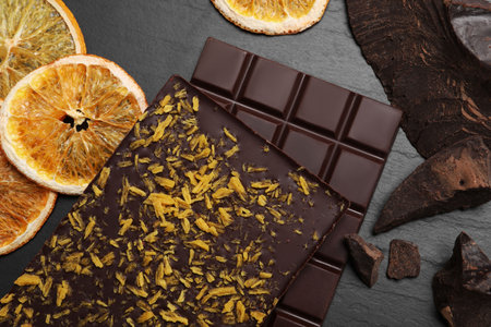 Chocolate bars with freeze dried orange on slate table, flat layの写真素材
