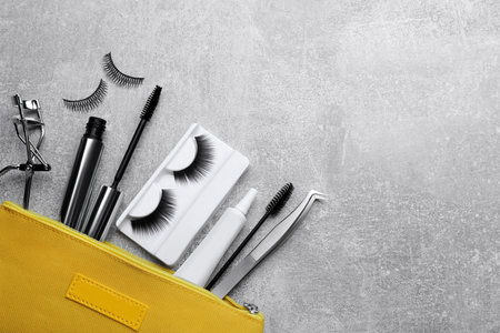 Flat lay composition with false eyelashes and tools on light gray background. Space for textの写真素材