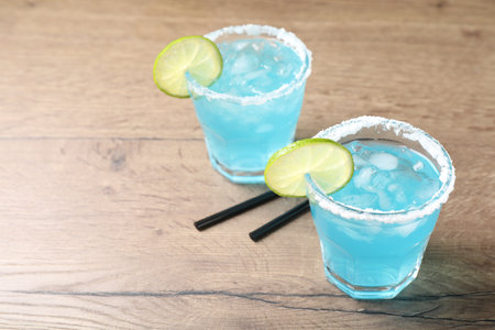 Refreshing light blue cocktail on wooden table, space for textの写真素材