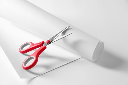 Red scissors and paper on white backgroundの写真素材