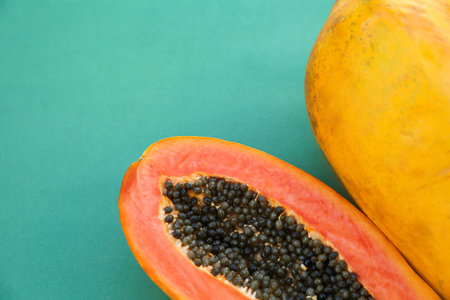 Fresh ripe cut and whole papaya fruits on light blue background, flat lay. Space for textの写真素材
