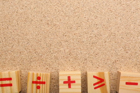 Wooden cubes with mathematical symbols on fiberboard, flat lay. Space for textの写真素材