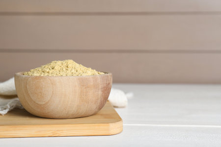 Bowl of aromatic mustard powder on white wooden table. Space for textの写真素材