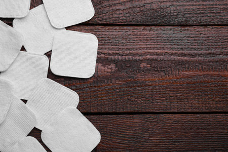 Many clean cotton pads on wooden table, flat lay. Space for textの写真素材
