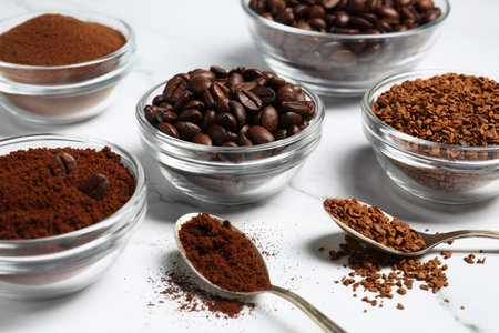 Bowls of beans, instant and ground coffee on white marble table, closeupの写真素材