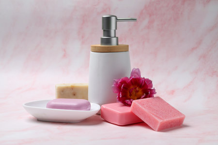 Soap bars and bottle dispenser on pink marble backgroundの写真素材
