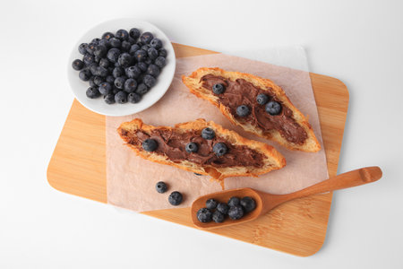 Tasty croissant with chocolate paste and blueberries on white background, above viewの写真素材