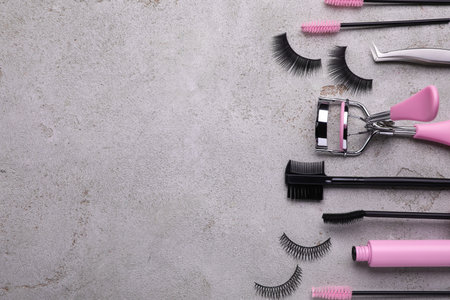 Flat lay composition with false eyelashes and tools on light gray background. Space for textの写真素材