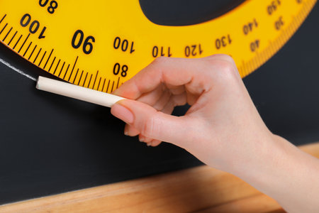 Woman drawing with chalk and protractor on blackboard, closeupの写真素材