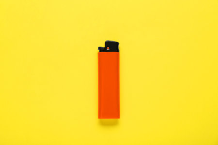 Stylish small pocket lighter on yellow background, top viewの写真素材