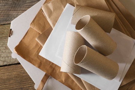 Stack of different waste paper on wooden table, flat layの写真素材