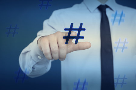 Hashtag concept. Man pointing at sign on blue background, closeupの写真素材