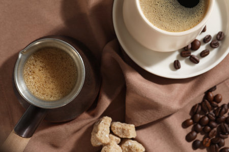 Turkish coffee. Cezve and cup with hot aromatic coffee, beans and sugar on table, flat layの写真素材