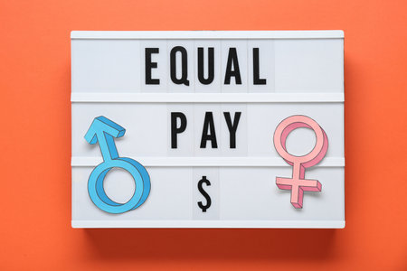 Equal pay. Lightbox and paper gender symbols on orange background, top viewの写真素材