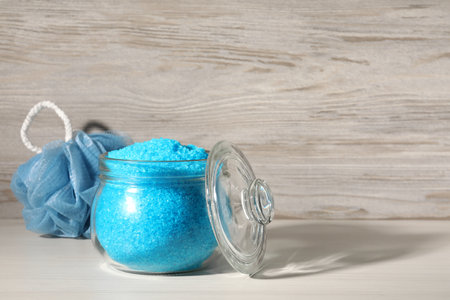 Aromatic sea salt and shower puff on white wooden table, space for textの写真素材