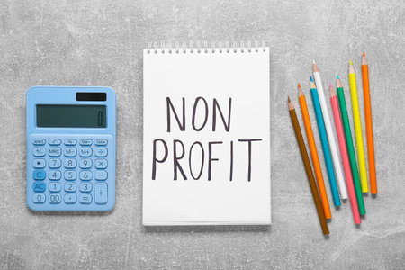 Non profit concept. Flat lay composition with notebook and pencils on light gray tableの写真素材