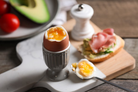 Soft boiled chicken egg served on wooden tableの写真素材