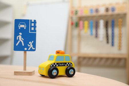Miniature road sign and car on wooden table, space for text. Montessori toyの写真素材
