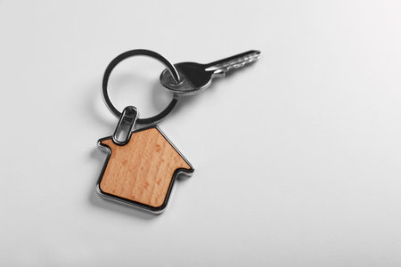 Key with trinket in shape of house on white background, above view and space for text. real estate agent servicesの写真素材