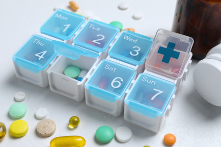 Weekly pill box with medicines on white table, closeupの写真素材