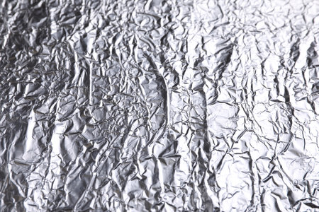Crumpled silver foil as background, closeup view