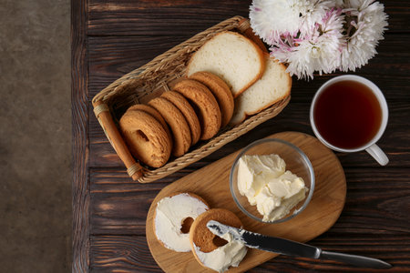 Tasty homemade butter, cookies and tea on wooden table, flat lay