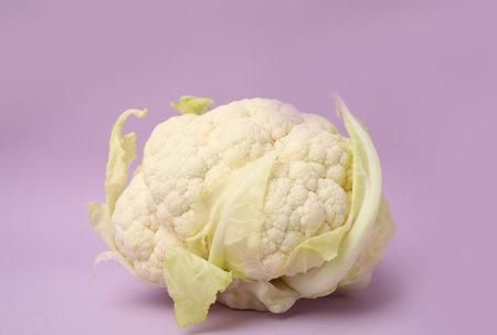 Whole fresh raw cauliflower on violet backgroundの写真素材