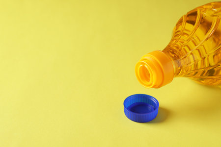 Plastic bottle of cooking oil on yellow background. Space for textの写真素材