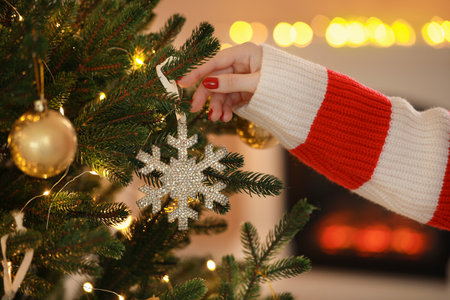 Woman decorating Christmas tree at home, closeupの写真素材