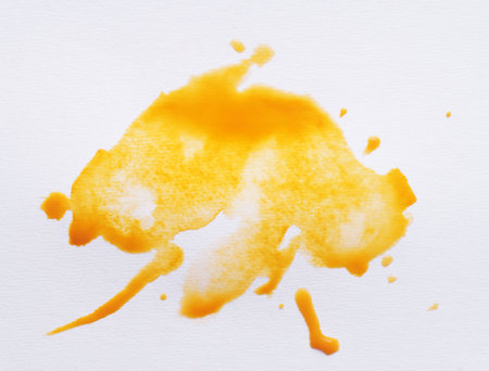 Blot of yellow ink on white background, top viewの写真素材