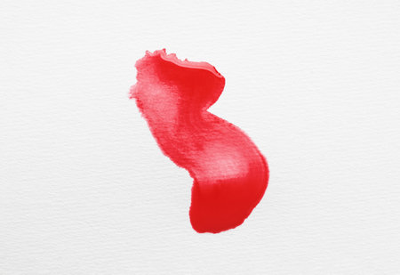 Blot of red ink on white background, top viewの写真素材