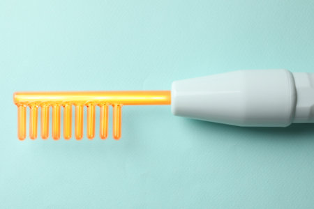 Working high frequency darsonval device on turquoise background, top viewの写真素材