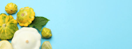 Fresh pattypan squashes on light blue background, flat lay with space for text. Banner designの写真素材