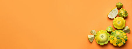 Fresh pattypan squashes on orange background, flat lay with space for text. Banner designの写真素材