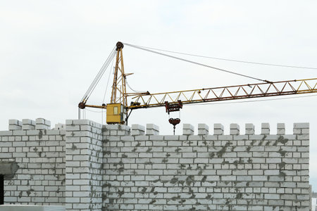 Construction site with tower crane near unfinished buildingの写真素材
