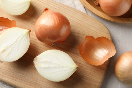 Whole and cut onions on table, flat layの写真素材