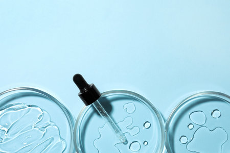 Petri dishes and pipette on light blue background, flat lay. Space for textの写真素材