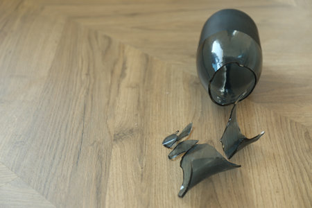 Broken blue glass vase on wooden floor. Space for textの写真素材