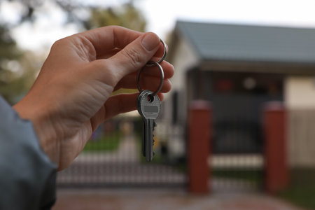 Real estate agent holding keys to new house outdoors, closeup. Space for textの写真素材