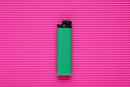 Stylish small pocket lighter on pink corrugated fiberboard, top viewの写真素材