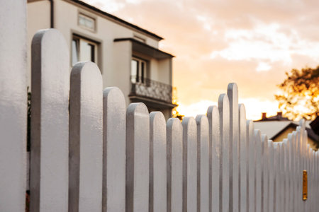 Houses behind beautiful white wooden fence outdoorsの写真素材
