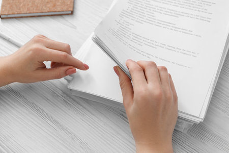Woman reading documents at white wooden table in office, above viewの写真素材