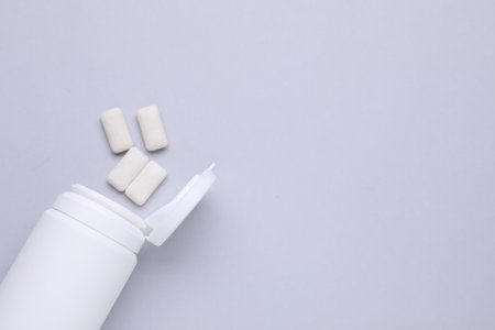 Jar with chewing gums on light gray background, flat lay. Space for textの写真素材